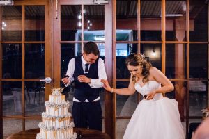 The bride & groom laugh after feeding each other cake at their Quarry Farm wedding.