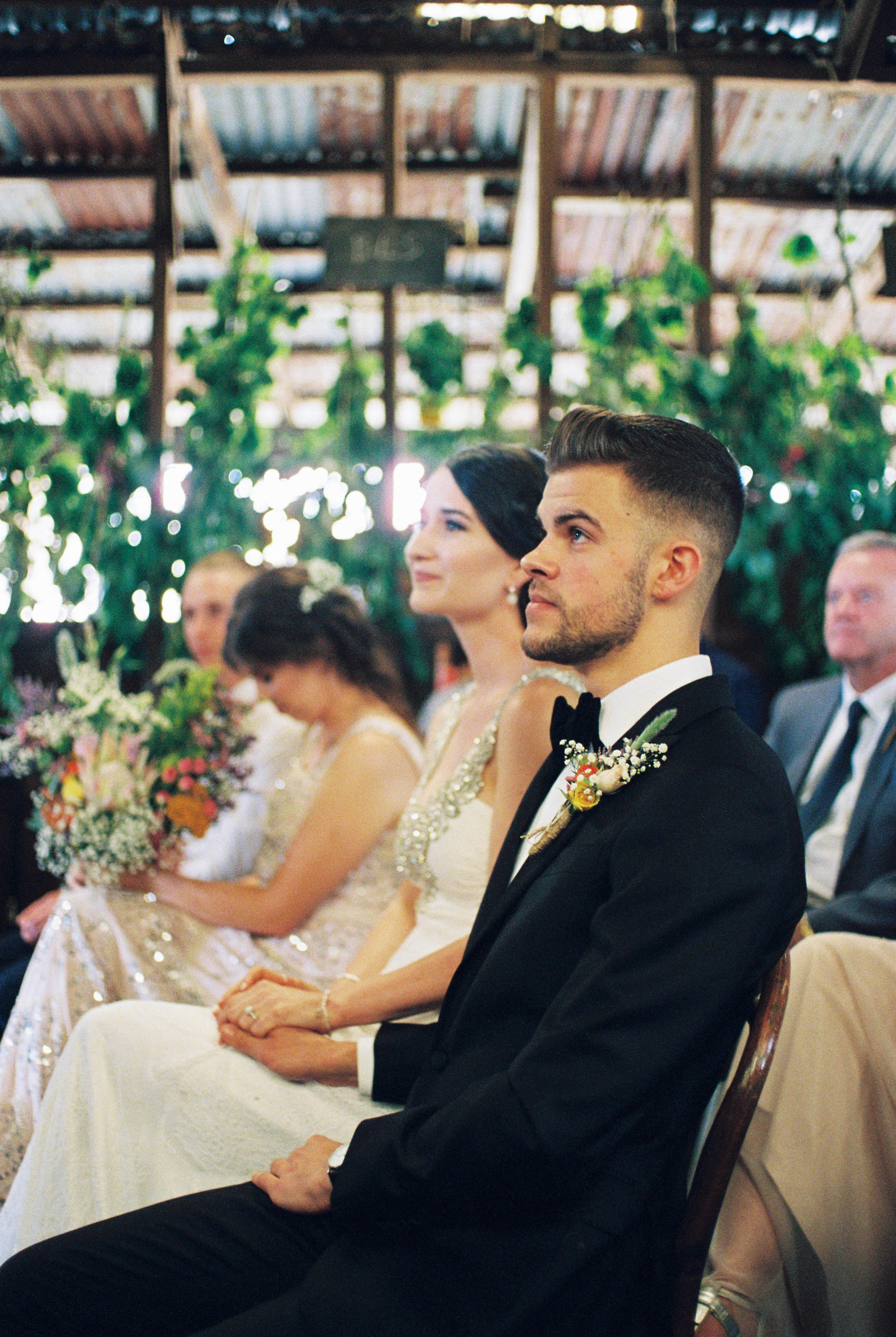 The bride and groom look towards the altar during their south west country wedding ceremony