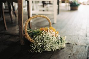 A photo of a basket of flowers decorating a Shearing Shed in Bridgetown for a wedding ceremony taken by Rhianna May Destination Wedding Photography