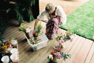 A photo of a stylist putting together flower decorations for a wedding in a shearing shed in Bridgetown