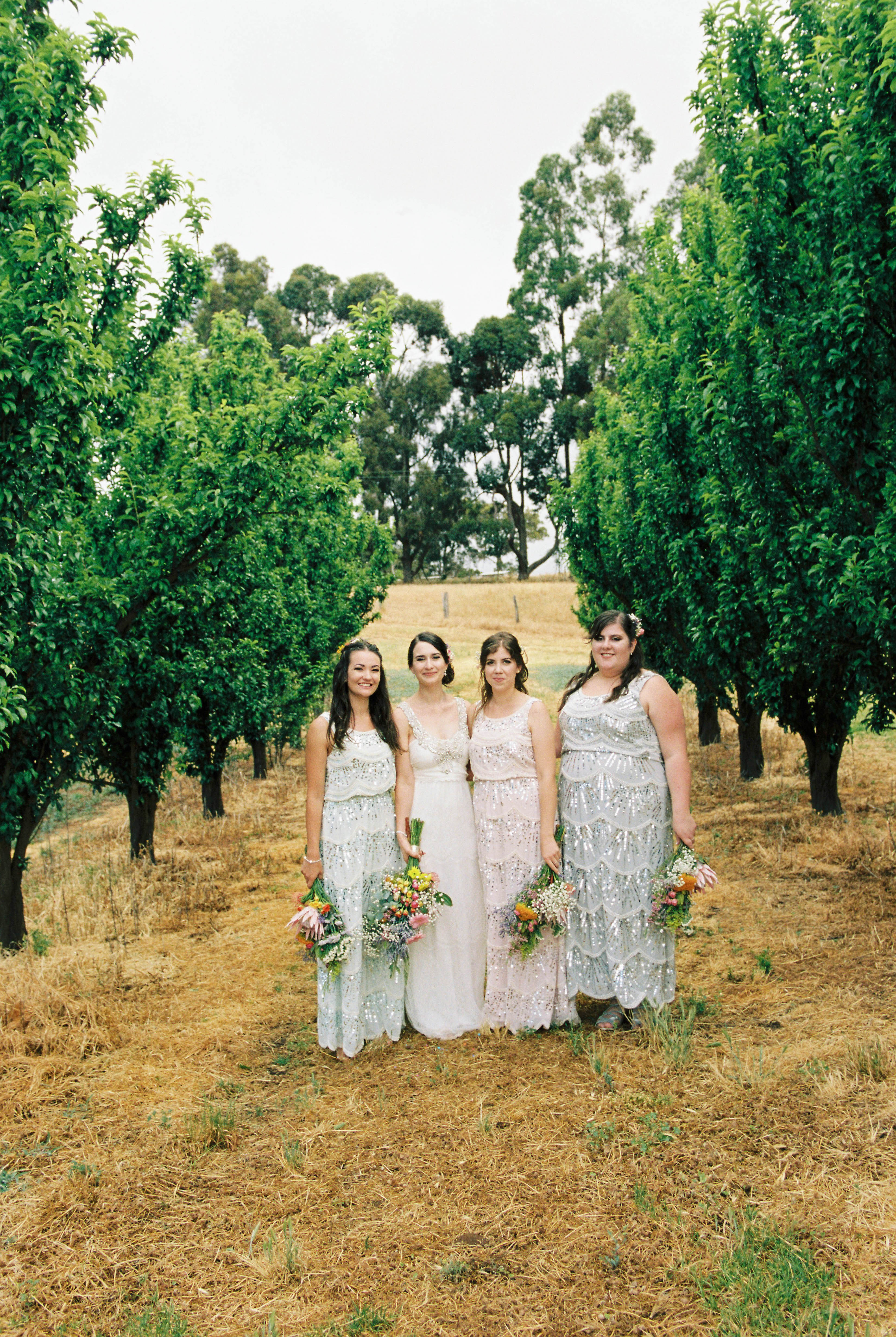 A natural wedding portrait of a bride with her bridesmaids on the south west family farm
