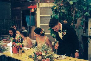 An authentic analogue photography of the bride & groom sitting down at their shearing shed reception