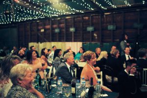 A candid photo of guests looking on during the speeches at a Shearing Shed Wedding Reception