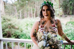 A portrait of the bride on the morning of her wedding, wearing a custom Harriette Gordon dress, foraged eucalyptus in her hair and a Covet Collect bridal bouquet.