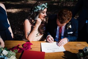 Authentic wedding photography of the bride & groom singing their Australian wedding certificate.