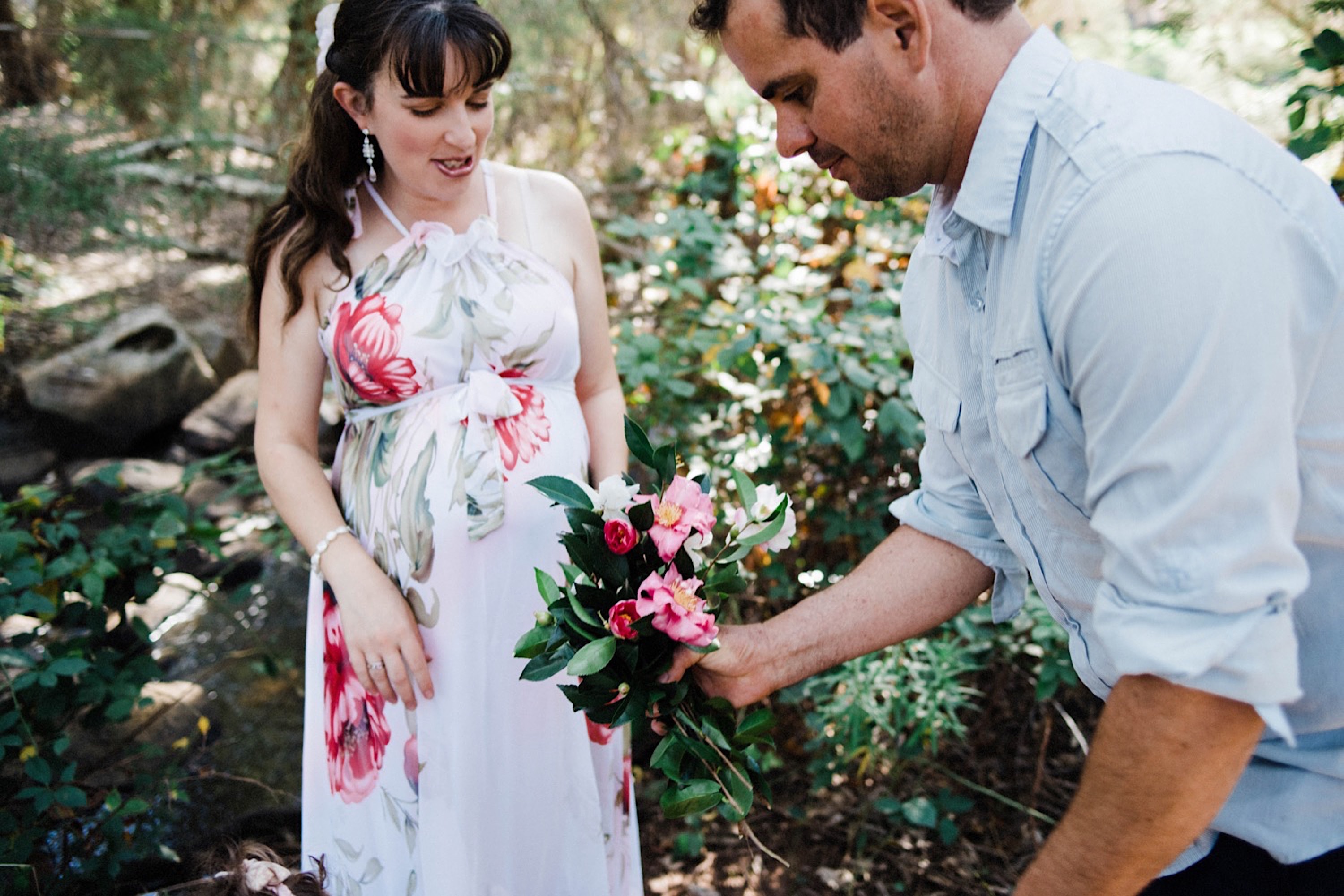 A candid portrait of a young Father giving his wife flowers that he picked for her during an Adventure Photo Session.