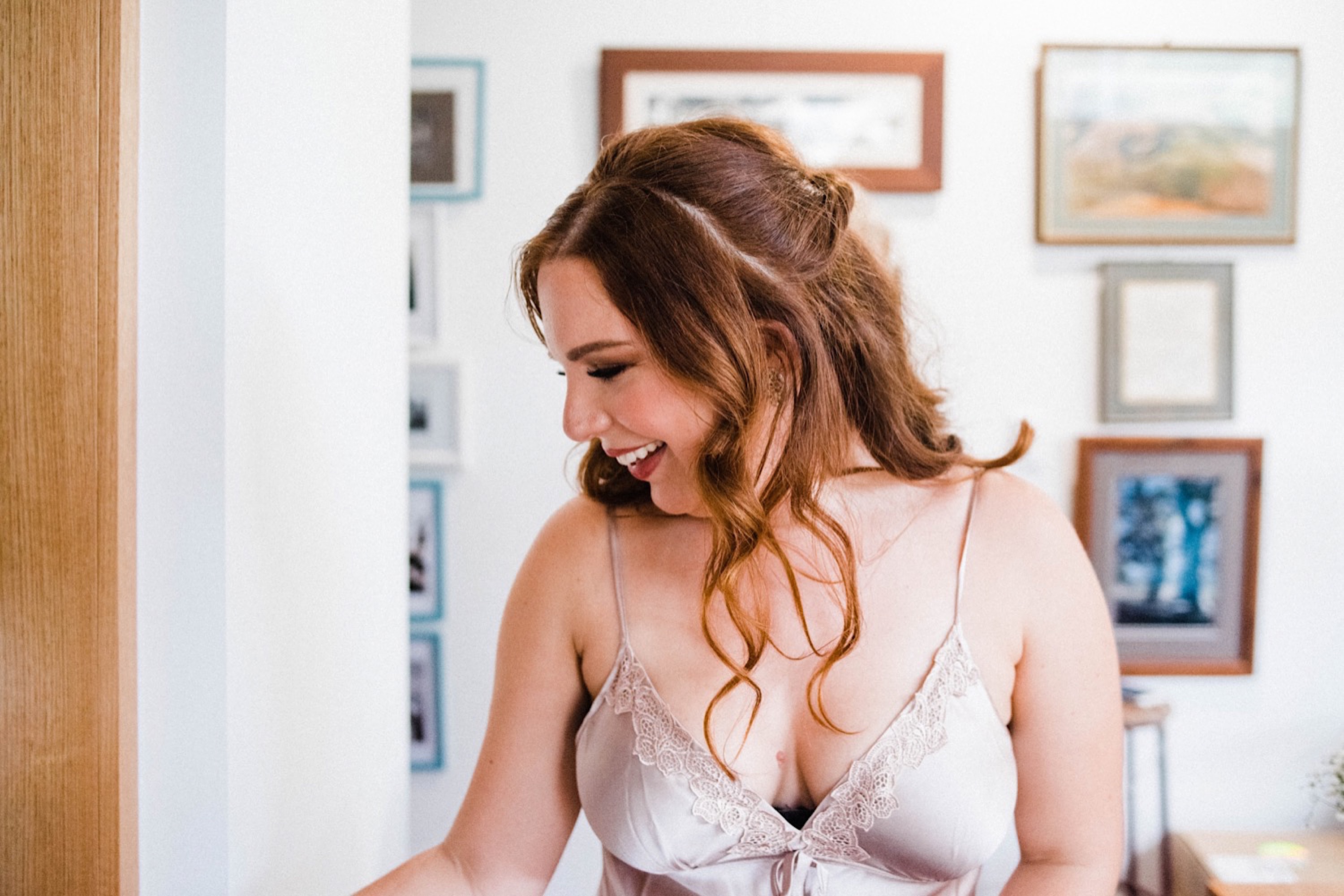 Documentary Wedding Photography of the Bride, with red hair and wearing a blush slip, making coffee in the kitchen the morning of her wedding.