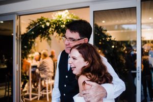 Documentary wedding photography of the bride hugging her Dad at her Sustainable Backyard Wedding.