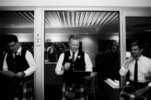 A black & white documentary photo of the father's of the bride & groom during speeches.