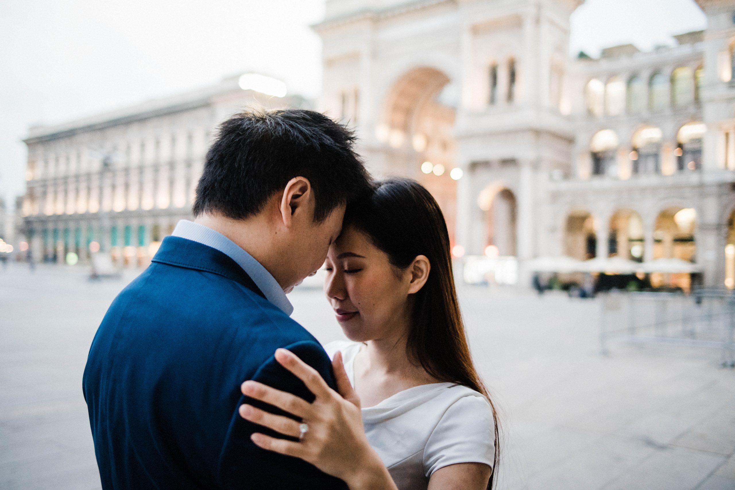 Destination Wedding Photography of a couple standing close together with their eyes closed in the Piazza del Duomo in Milan, Italy.