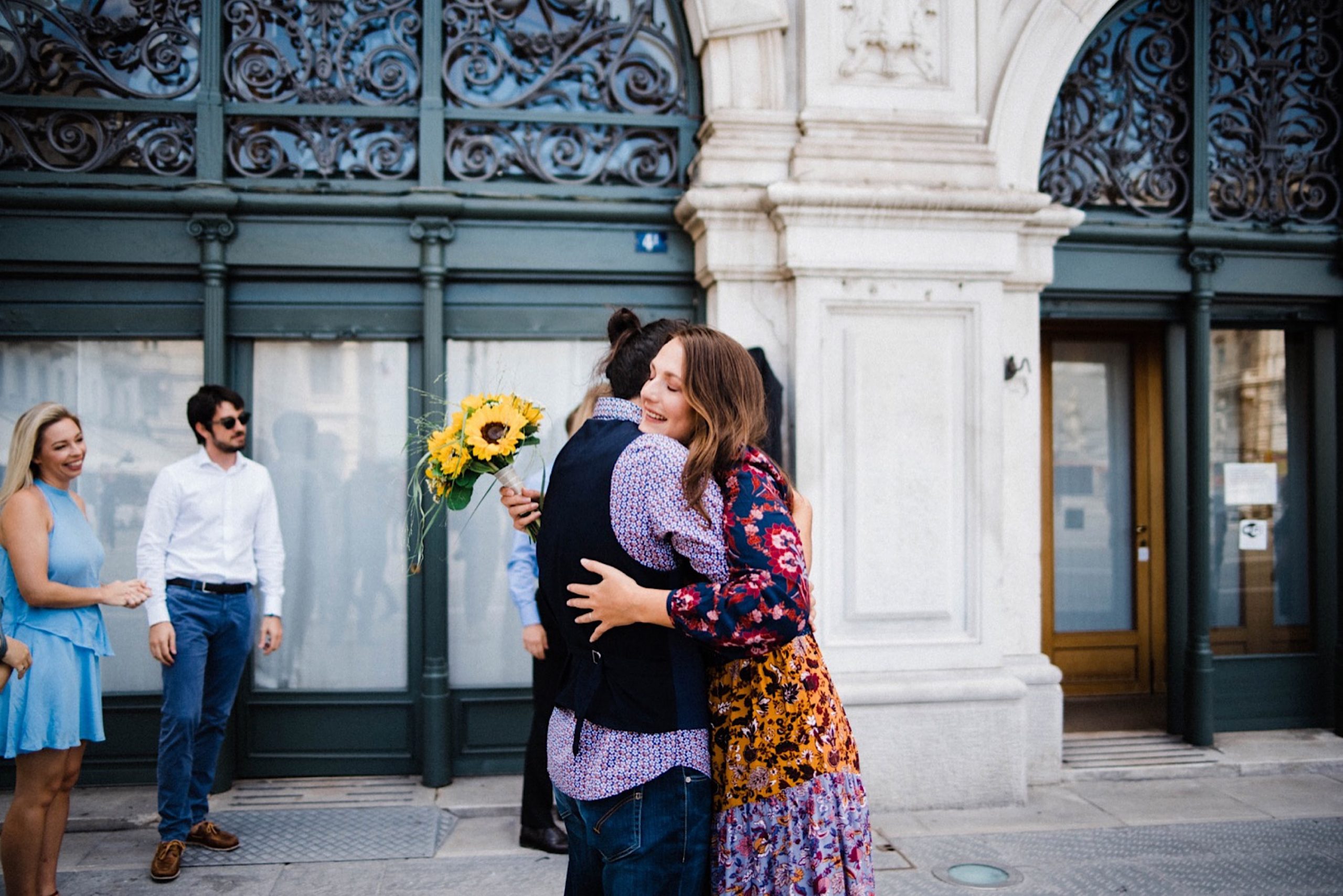 A wide photo of newlyweds hugging each other in the Piazza Unità in Trieste, after their wedding ceremony.