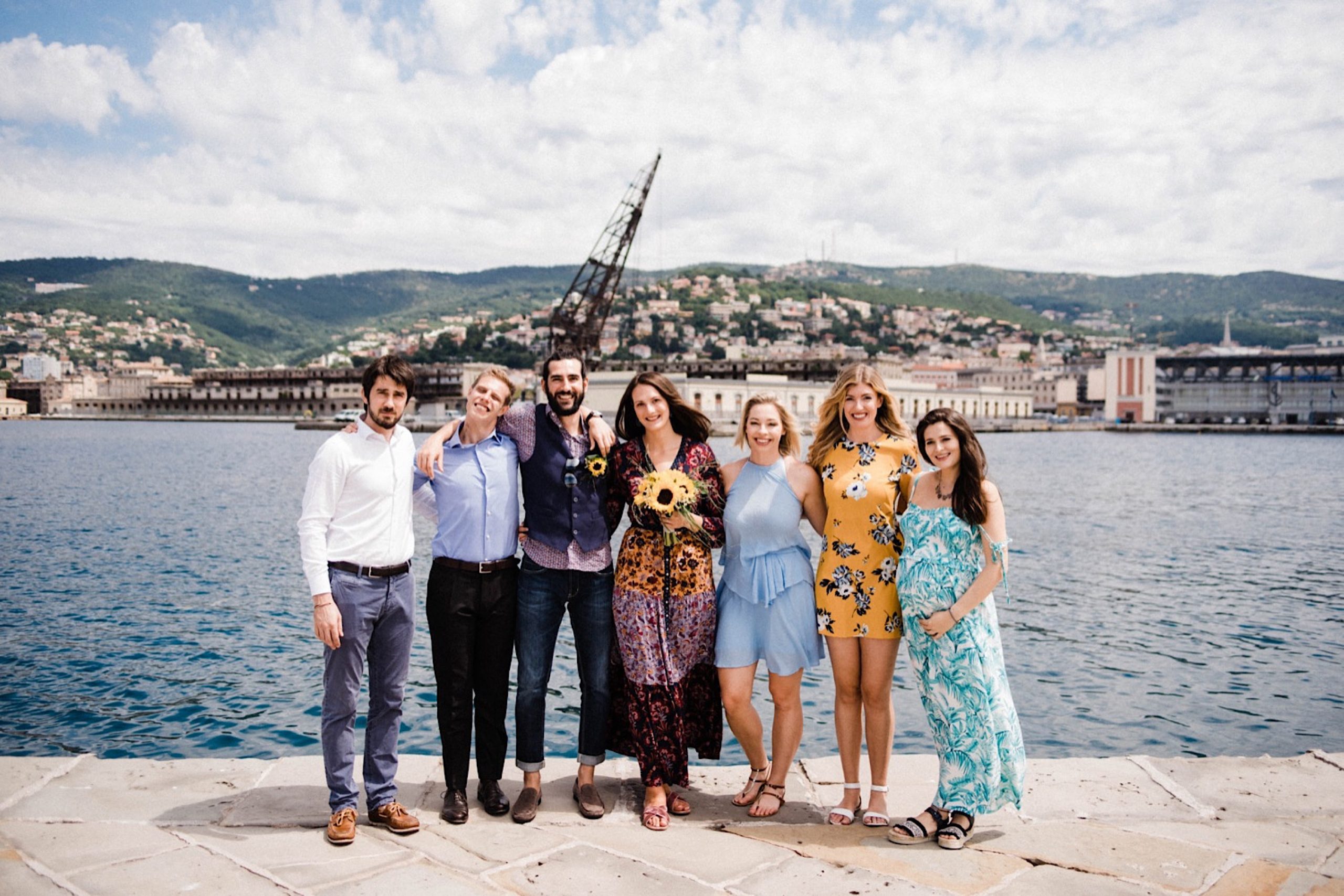 A group photo looking out over the Trieste port after a small wedding.