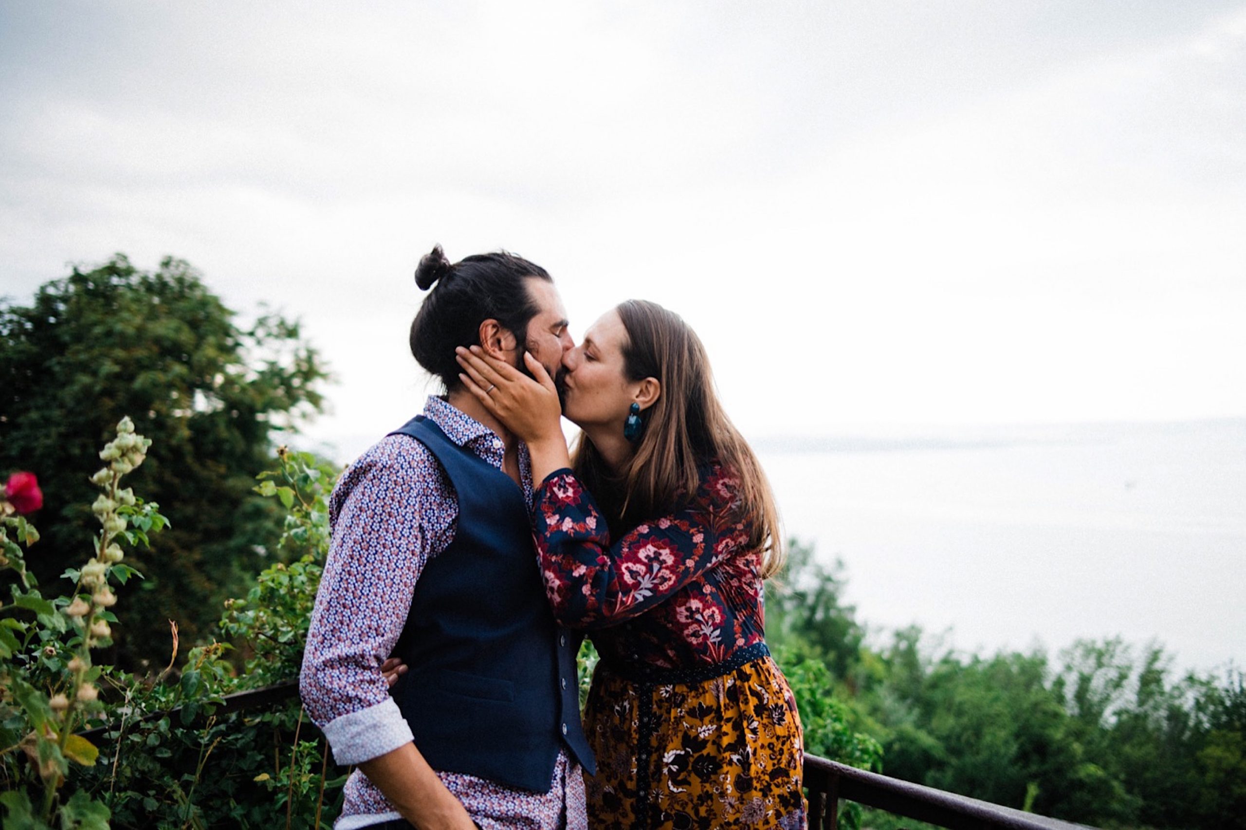 Relaxed wedding photography of a newlywed couple kissing in front of a garden, looking over the Adriatic Sea near Trieste.
