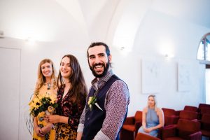 A wide photo of newlyweds smiling in the Sala Bobi Bazen in Trieste, Italy.