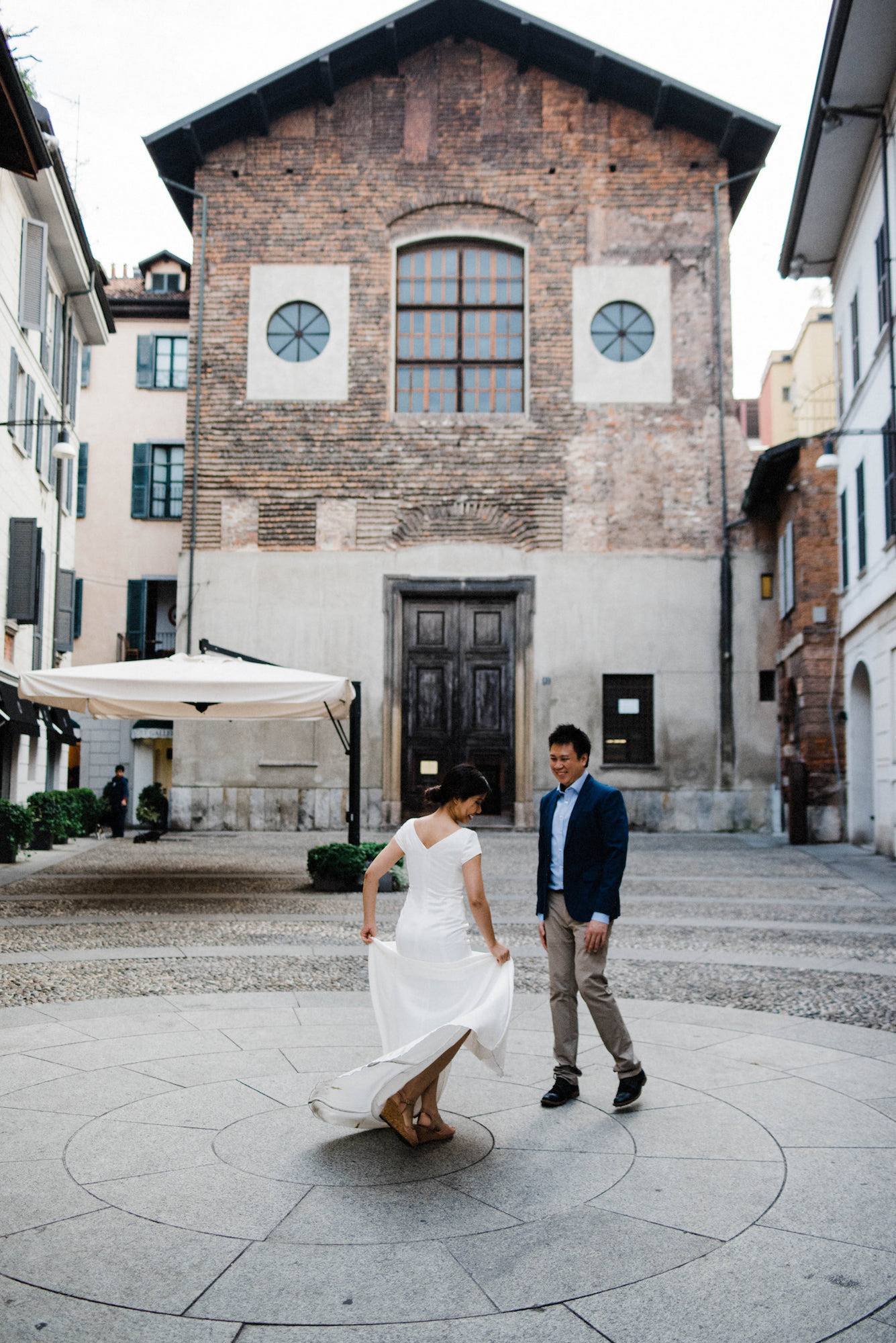 A portrait-oriented photo of a couple dancing in a square during their Italian Elopement in Milan.